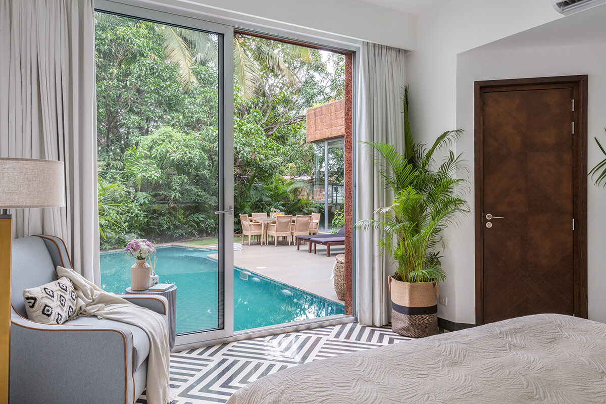 Bedroom with a pool view at La Orilla villa in Assagao