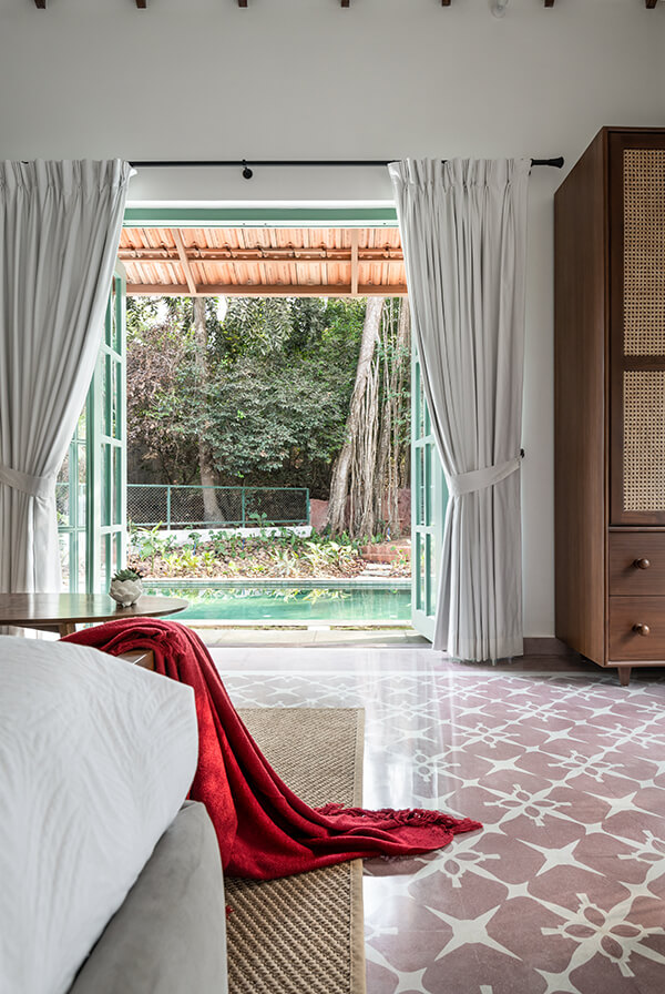 Bedroom opening into the pool area at a villa in Assagao